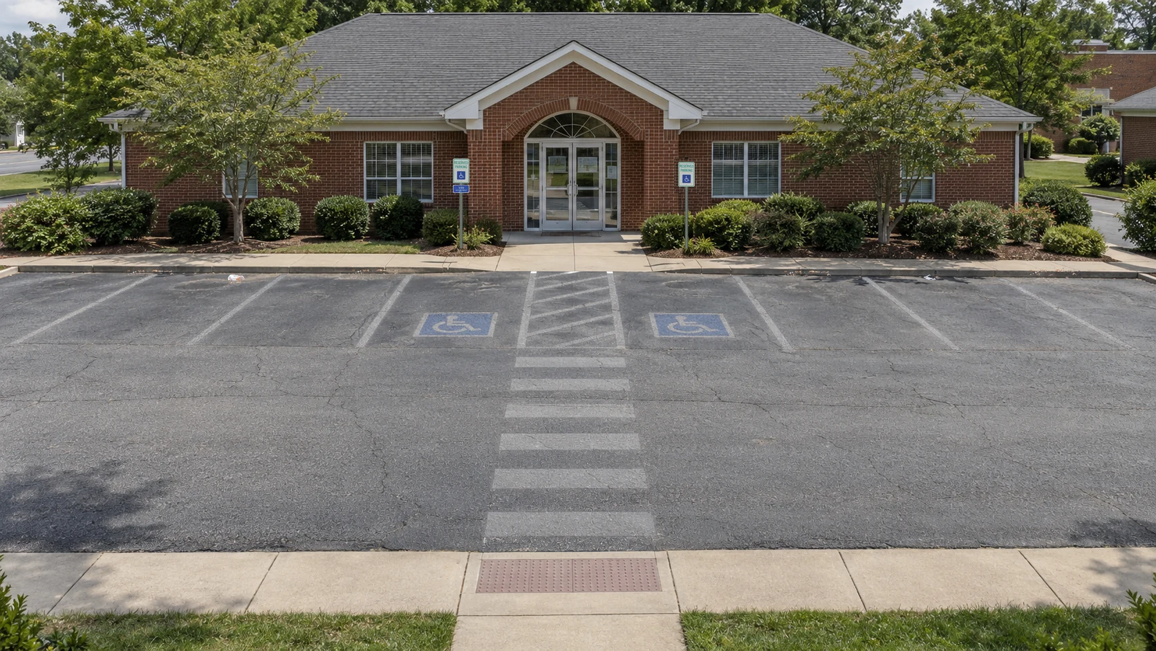 Office lot before cleanup, with faded markings and light curb-line litter